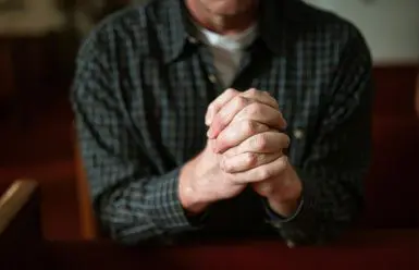 A man with his hands clasped together.