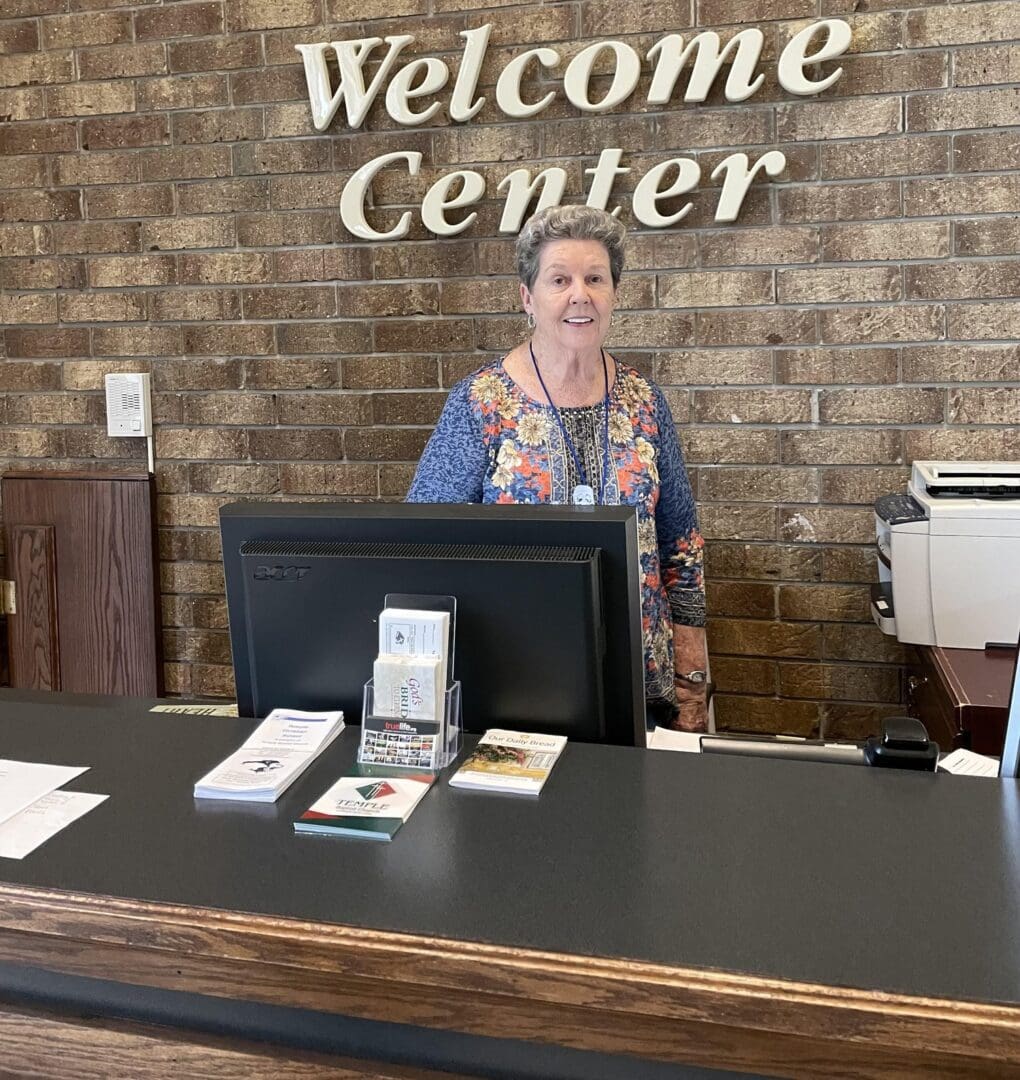 A woman standing at the front of a welcome center.